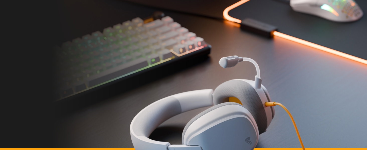 Configuration de l'espace de travail avec une lampe à clip crème à lumière chaude fixée au bord du bureau, positionnée à proximité d'un ordinateur portable et d'un casque sur une surface sombre de la table.