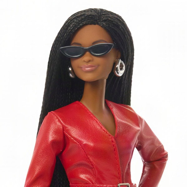 Poupée Barbie aux longs cheveux raides noirs, portant des lunettes de soleil foncées et une veste en cuir rouge. La figure montre des articulations pour la pose et le style.