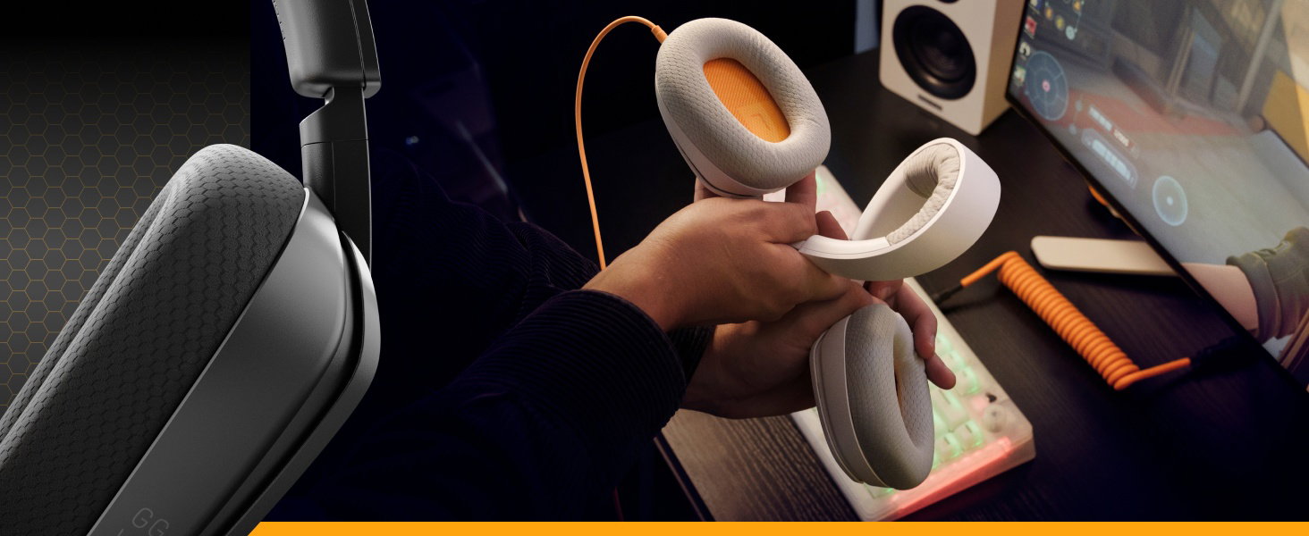 Angle similaire à celui de l'image 4, montrant des mains travaillant avec un casque ou un appareil audio blanc, avec un équipement supplémentaire visible dans le cadre.