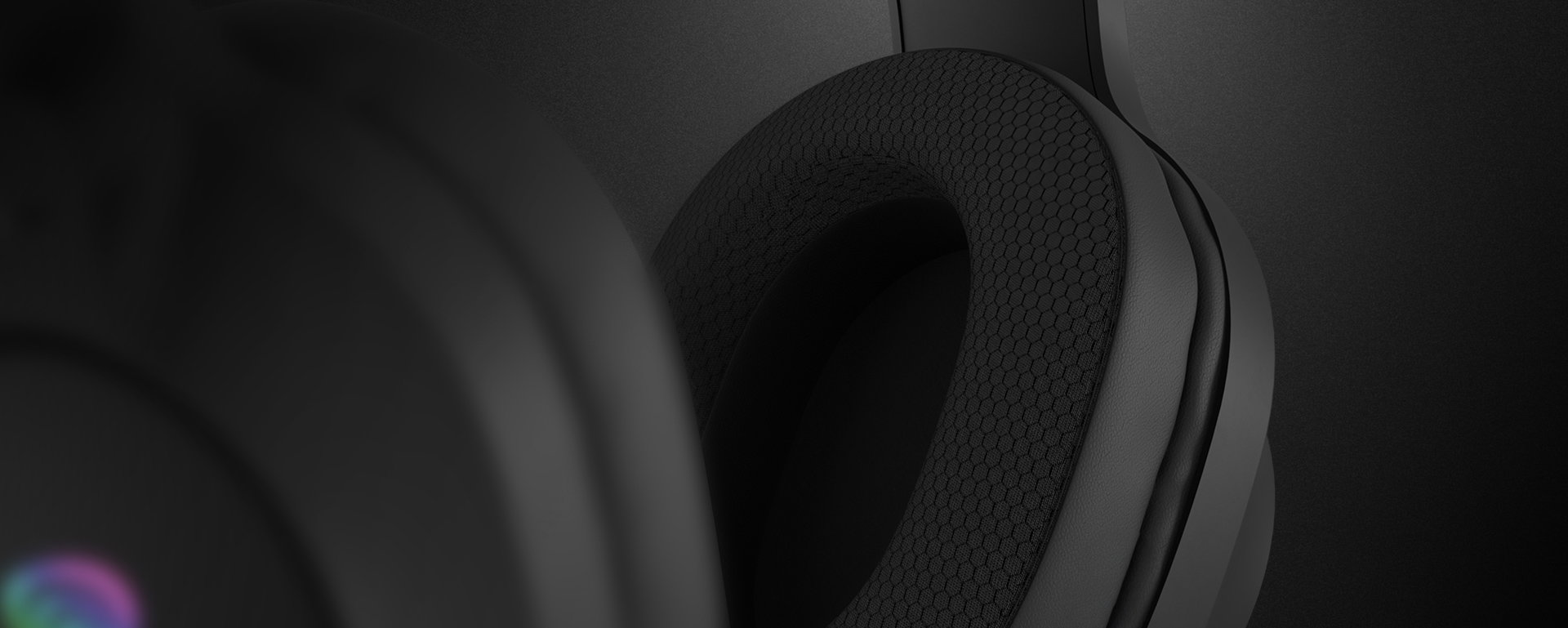 Black over-ear headphones with a textured ear cushion and colorful backlighting