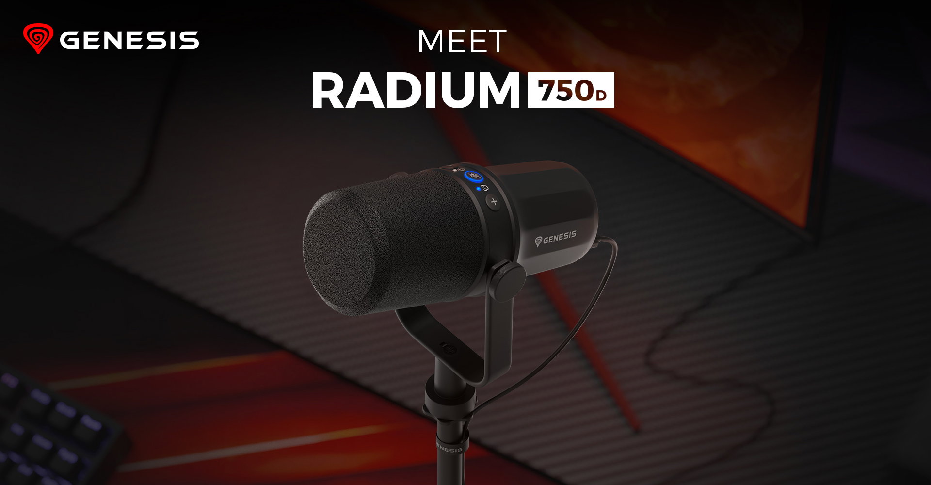 Microphone on a stand with a black mesh cover and blue indicator light beside a computer setup