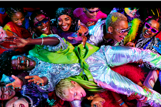 MacBook Pro con la pantalla a todo color que muestra a una persona persona llevada en volandas en una fiesta, destaca la nitidez de la pantalla Liquid Retina XDR
